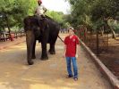 A man leads the elephant to drink water. Or vice versa.